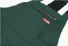 A close-up view of the chest pocket area of a green pair of overalls. Anteprima dell’immagine prodotto