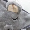 A close-up view of a gray hooded towel with embroidered eyes and ears, resembling an animal. Produktbild-Vorschau