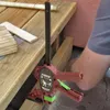 A person is using a clamp to hold wooden planks together. Náhled obrázku produktu