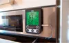 A digital thermometer is attached to a stainless steel oven door. Produktbild-Vorschau