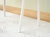 Close-up of the white legs of a desk on a rug and wooden floor. Voir les images du produit