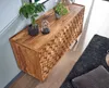 A wooden sideboard with decorative carvings is shown in a room setting, with plants on top and a rug nearby. Anteprima dell’immagine prodotto