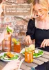 Two people are enjoying a meal outdoors with drinks and salads. Produktbild-Vorschau
