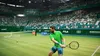 A tennis player in a green shirt and blue shorts is playing tennis on a green court in a stadium filled with spectators. Produktbild-Vorschau