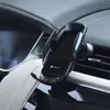 A black wireless car phone charger mounted on a car's air vent. Produktbild-Vorschau