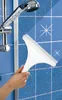 A hand is using a squeegee to clean a tiled shower wall with water droplets on it. A shower head is visible in the background. Produktbild-Vorschau