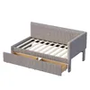 A gray upholstered daybed with two open drawers underneath, shown from a slightly elevated side angle against a white background. Anteprima dell’immagine prodotto