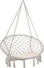 A beige macrame hanging chair with a cushion, suspended by ropes against a white background. Náhled obrázku produktu