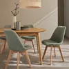 A dining set with a wooden table and green chairs in a room with textured walls and natural light. Anteprima dell’immagine prodotto
