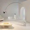 A modern living room with a large arc floor lamp, a unique coffee table, and architectural elements. Anteprima dell’immagine prodotto