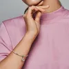 A woman's arm wearing a silver bracelet with a charm, against a pink background. Produktbild-Vorschau