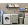 A laundry room with a washing machine, sink, and various cleaning supplies. Anteprima dell’immagine prodotto