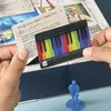 Hands holding cards with musical notes and a keyboard illustration over a game board. Produktbild-Vorschau