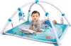 A baby is playing on an ocean-themed playmat with a play gym. Produktbild-Vorschau