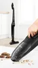 A hand is using a black Bosch handheld vacuum cleaner to clean up cookie crumbs from a white surface. Another Bosch stick vacuum cleaner is visible in the background. Produktbild-Vorschau