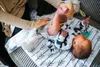 A person is changing a baby's diaper on a changing mat. Anteprima dell’immagine prodotto