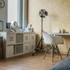 A home office or studio space with a fan on a shelf, a desk with a chair, and a lighting fixture. Anteprima dell’immagine prodotto