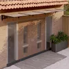 A door canopy is installed above a double door entrance to a house. Náhled obrázku produktu
