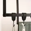 A close-up view of black S-hooks attached to a horizontal bar, with parts of green and white fabric hanging from two of the hooks. Anteprima dell’immagine prodotto