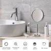A makeup mirror on a bathroom counter next to a sink and toiletries. Produktbild-Vorschau