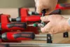Hands using a tool to tighten a clamp. Produktbild-Vorschau