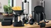 A collection of black kitchen utensils and accessories arranged on a wooden countertop. Náhled obrázku produktu