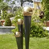 Three decorative garden spheres on stands in a garden setting. Produktbild-Vorschau