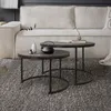 Two nesting coffee tables are placed on a textured rug in front of a sofa. Produktbild-Vorschau