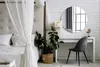 A bedroom scene with a bed, a vanity table with a chair, and a round mirror. Produktbild-Vorschau