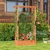 A wooden raised garden bed with a trellis structure, filled with various flowering plants and vines, set in a garden with a wooden house in the background. Podgląd zdjęcia produktu