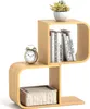 A modern, S-shaped bamboo bookshelf with books, a plant, and an alarm clock. Podgląd zdjęcia produktu