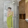 A woman wrapped in a green towel stands in a modern bathroom, in front of a white shower panel. Náhled obrázku produktu