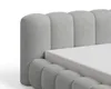 A close-up view of a grey upholstered bed frame with a white mattress. Voir les images du produit