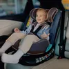 A child is sitting in a car seat in the back seat of a car. Produktbild-Vorschau