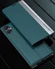 A teal flip phone case with a silver accent strip is shown on a dark, reflective surface. Produktbild-Vorschau