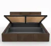A brown upholstered bed frame with the mattress support mechanism open, revealing storage space underneath. Podgląd zdjęcia produktu
