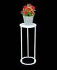 A white metal plant stand with a potted plant on top. Produktbild-Vorschau