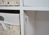 Close-up view of a white wooden cabinet with a woven basket drawer and a magnetic catch. Produktbild-Vorschau