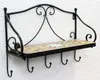 A black metal wall shelf with a mosaic tiled surface and four hooks underneath, mounted on a white wall. Podgląd zdjęcia produktu