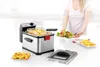 A woman is serving a salad next to a deep fryer filled with french fries. There are also chicken nuggets on a plate. Produktbild-Vorschau