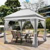 A gazebo with a table and chairs set up on a wooden deck in a backyard. Produktbild-Vorschau