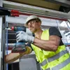 A construction worker is using a Bosch drill to install something. Produktbild-Vorschau