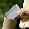 A person is placing a silver Xiaomi portable photo printer into a straw bag. Anteprima dell’immagine prodotto