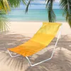 A yellow and orange striped beach chair on a sandy beach with palm trees and the ocean in the background. Voir les images du produit