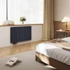 A bedroom scene with a radiator under a window, a bed, and a nightstand. Náhled obrázku produktu