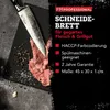 A close-up of a knife cutting a piece of meat on a black cutting board, with text overlays describing the product's features. Produktbild-Vorschau