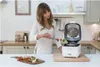 A woman is preparing food in a kitchen, using an air fryer. Produktbild-Vorschau