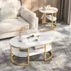A living room scene with a sofa and two marble-effect side tables with gold metal frames. Produktbild-Vorschau