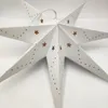 A white paper star lantern with gold star cutouts and dots, set against a white background. Produktbild-Vorschau