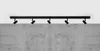 A black track light fixture with five adjustable spotlights mounted on a ceiling above a concrete wall. Náhľad obrázku produktu